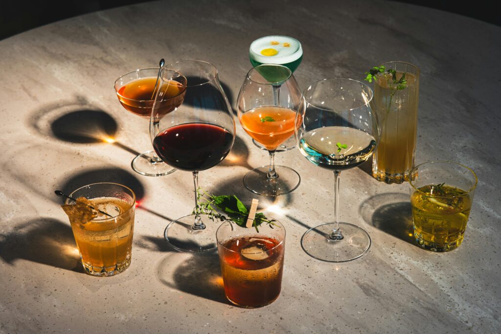 Array of colorful cocktails on a marble table in a Tokyo bar, highlighting vibrant drink artistry.